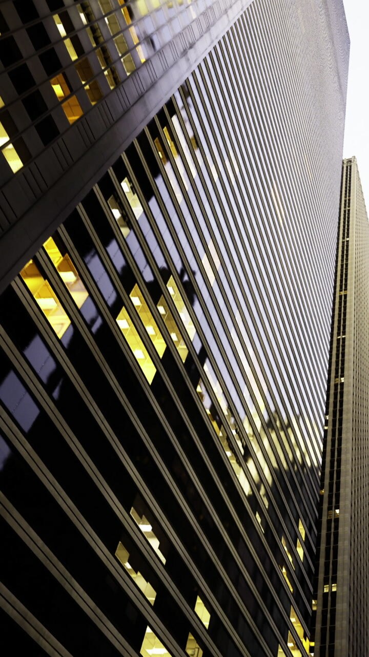 Building with reflective glass panels in city skyline during evening hours