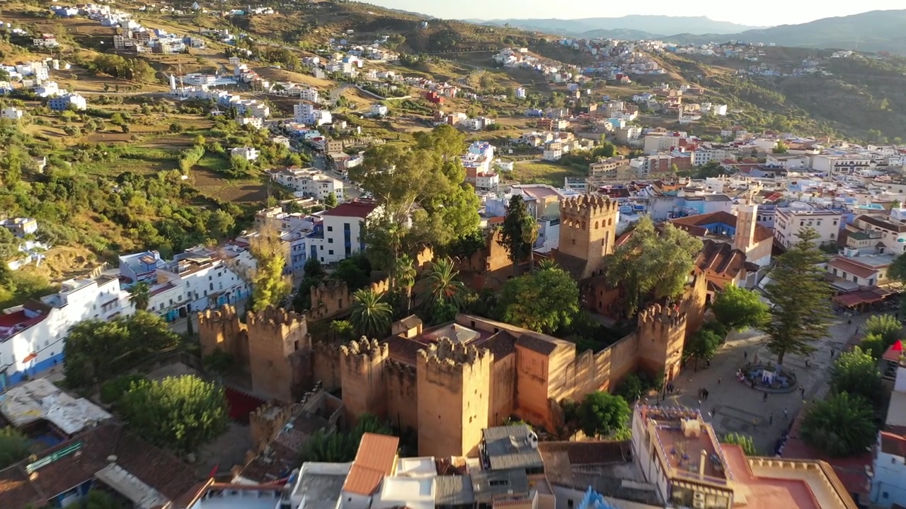 Drone-luftpanorama af Chefchaouen, der afslører dens ikoniske blå kvarterer, der strækker sig over Rifbjergene, en af Marokkos mest maleriske kultur- og turistdestinationer.