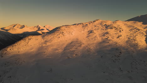 snowy summit of nesaksla during sunset in andalsnes, norway. - aerial