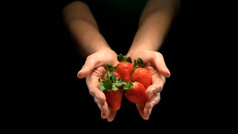 hands pouring strawberries 4k