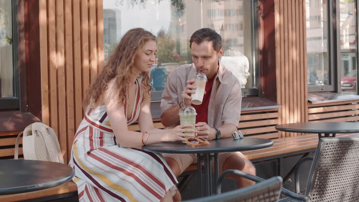 пара наслаждается напитками в открытом кафе