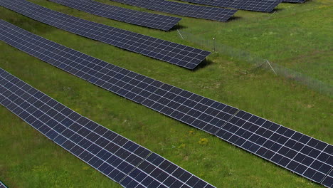 Flying-Low-over-Solar-Panels-Array-on-Green-Field-Land,-Alternative-Ecological-Electric-Energy-Technology-of-Pv-Modules-in-Countryside-of-Poland