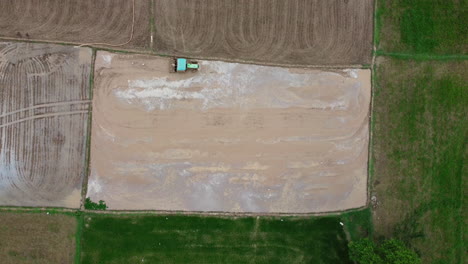 tractor plowing muddy land at the rice field