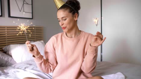 Cheerful-woman-having-fun-with-sparkler-in-birthday-morning