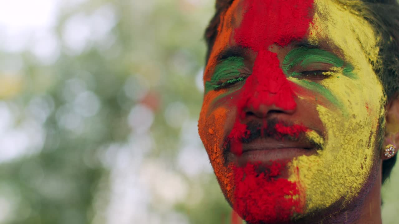 hombre indio de primer plano de la cara manchada con colores brillantes de holi