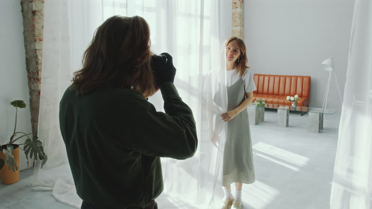 Female Model Posing behind Sheer Curtain and Smiling during Photo Session