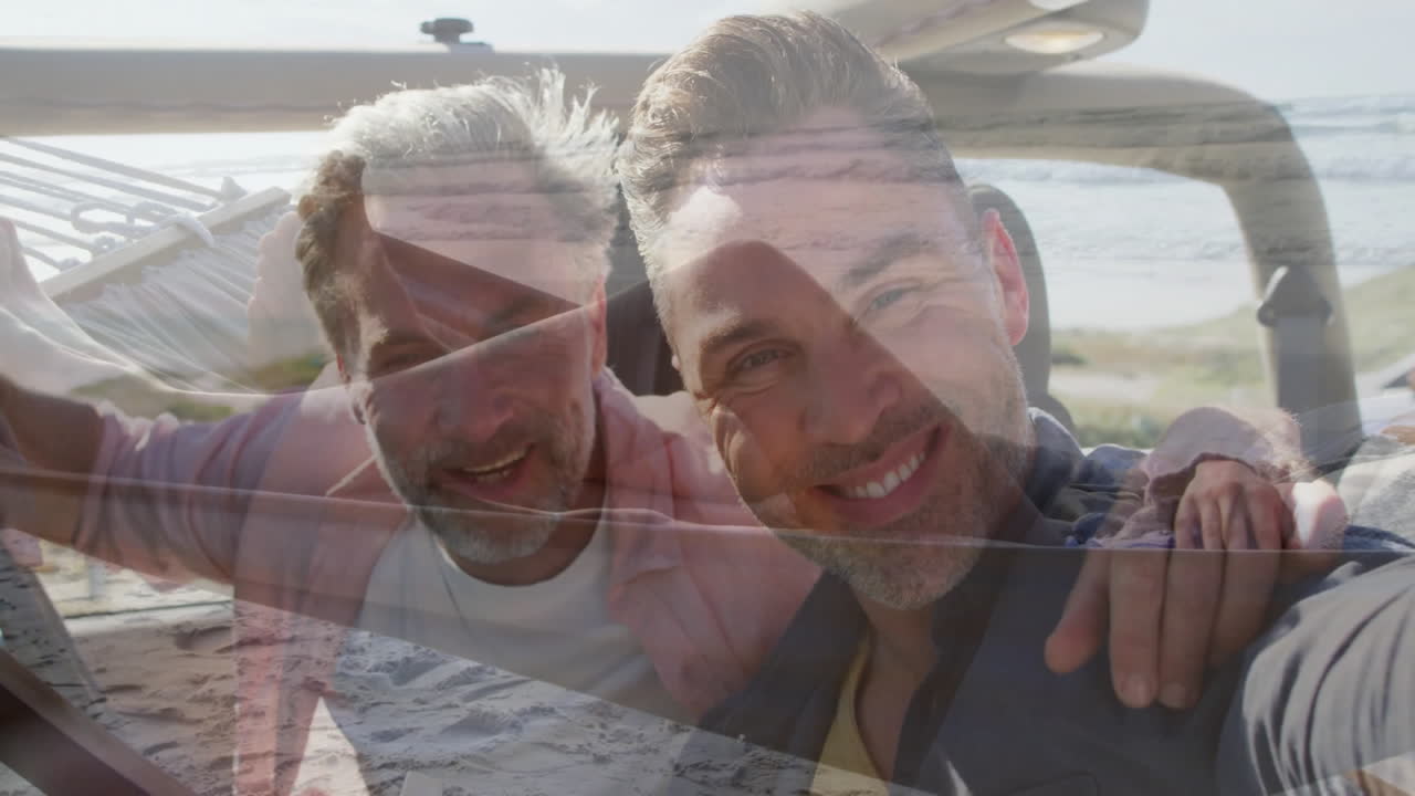 Embracing and smiling, two men enjoying animation on beach scene