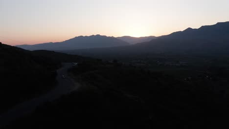 low aerial shot flying above a mountain road for ojai valley's famous "pink moment" in california