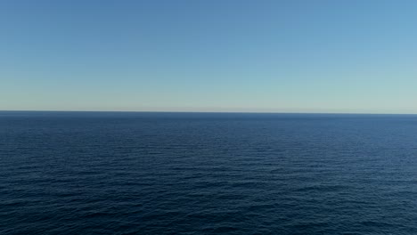 Vast view of the deep blue sea under a clear sky, showcasing tranquility