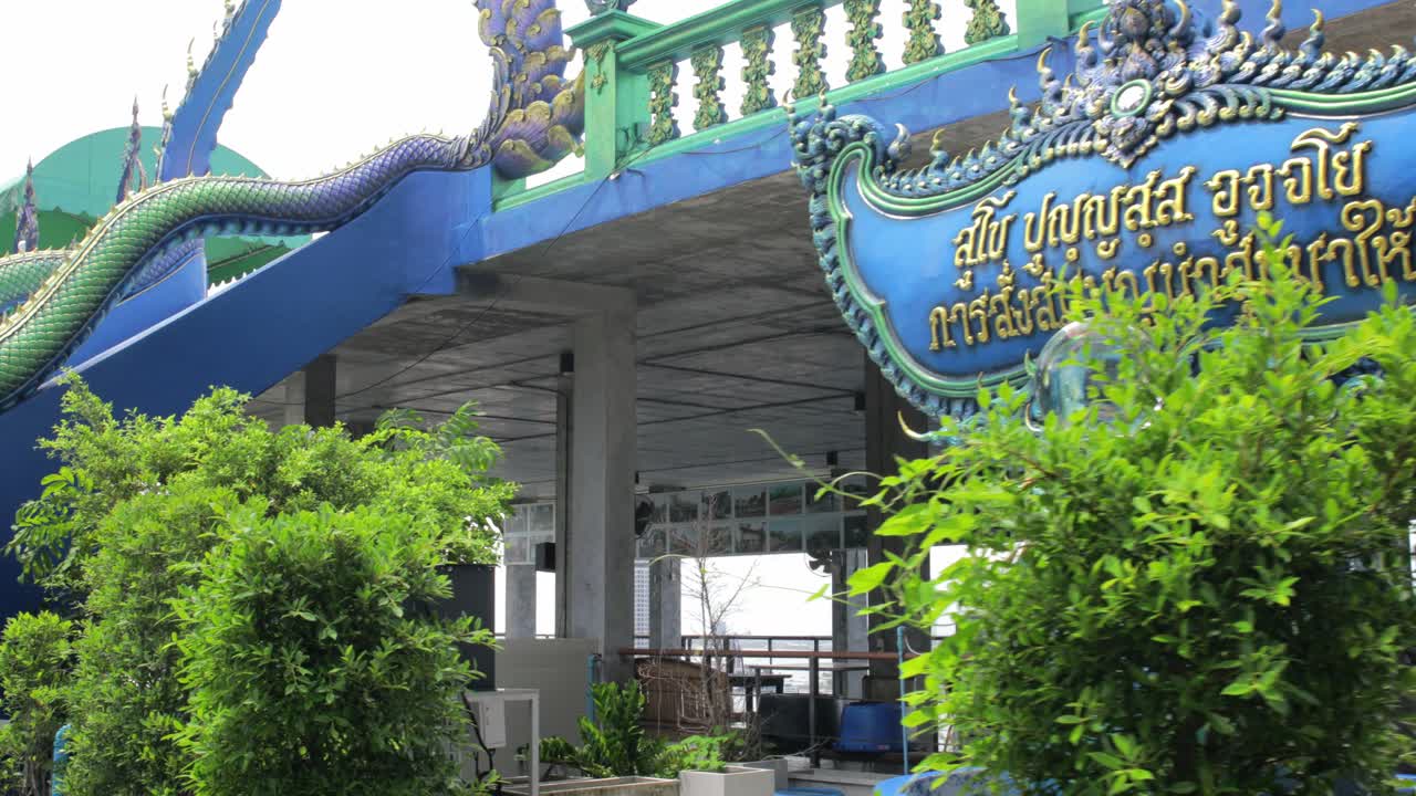 파란 모자이크 태국 중국 사원 표지판, 동상, 그리고 평화로운 녹색