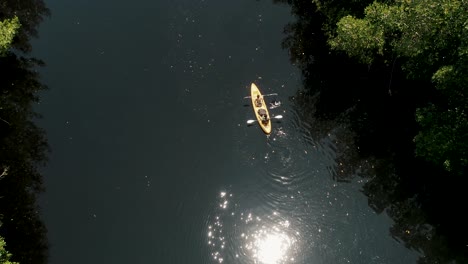 sunlight reflected on calm river with people kayaking in el paredon, escuintla, guatemala