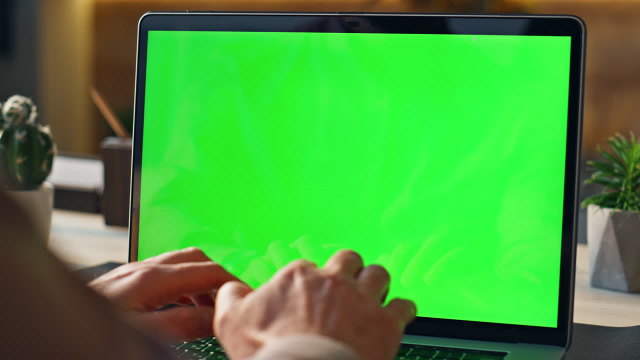 manos trabajando en un portátil de pantalla verde remoto en el lugar de trabajo de cerca. gerente escribiendo