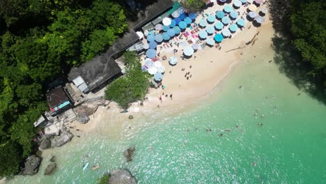 Looking-down-on-an-isolated-beach-in-the-south-of-Bali,-Indonesia-on-a-hot-summers-day,-aerial
