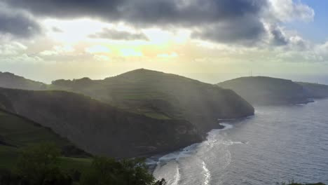 majestic sunlit atlantic ocean coastline with sunrays in azores, aerial