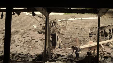 woman moving rubble and debris after disaster