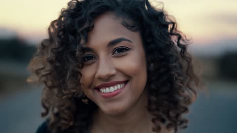 close up shot features a young brazilian woman with curly hair and a nose ring, smiling and posing confidently. her joyful expression radiates beauty and authenticity