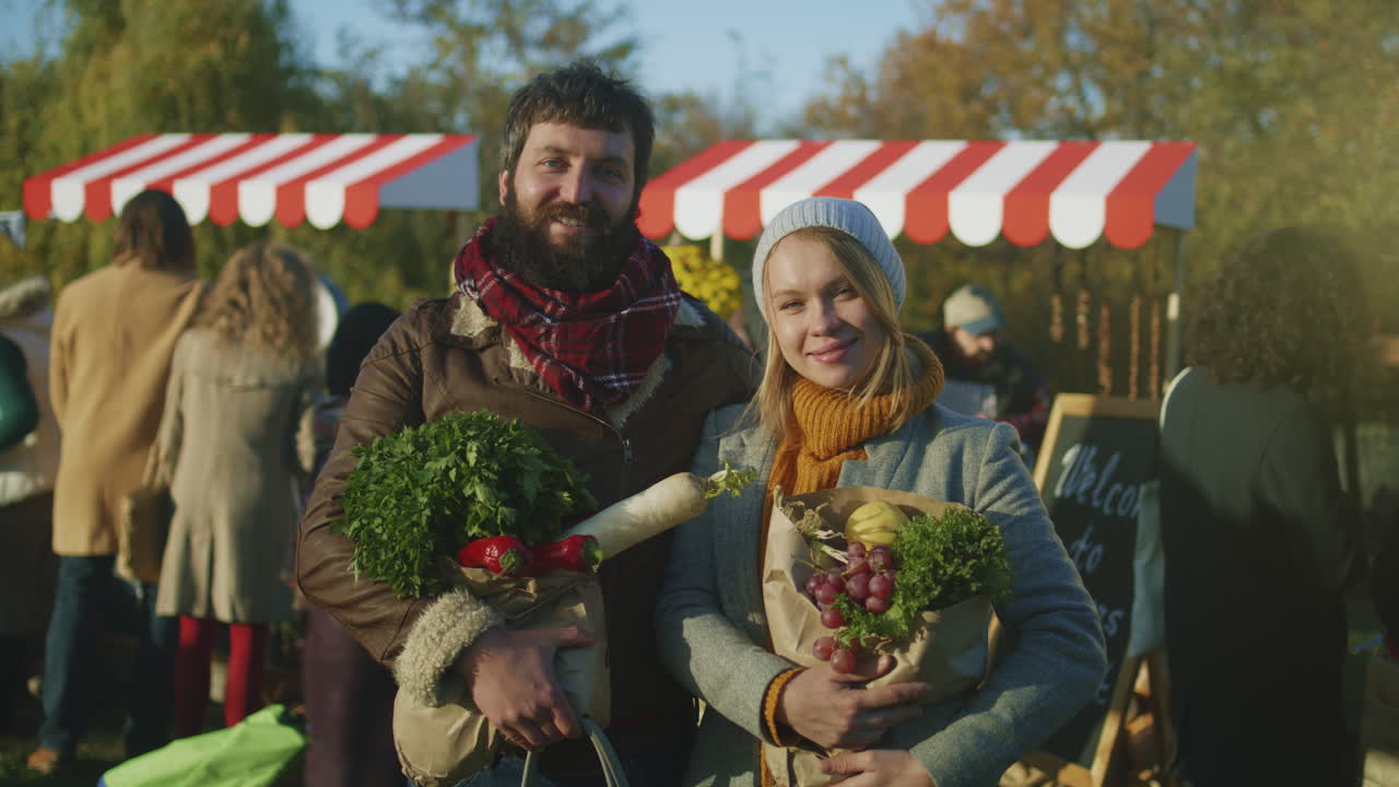 Spouses Posing with Bag of Fruits Spouses Posing with Bag of Fruits or Vegetables and Looking at Camera Smilling and Feeling Happy after Shoping on Farmers Market