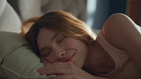 sleepy woman reading cellphone message waking up sunny morning close up.