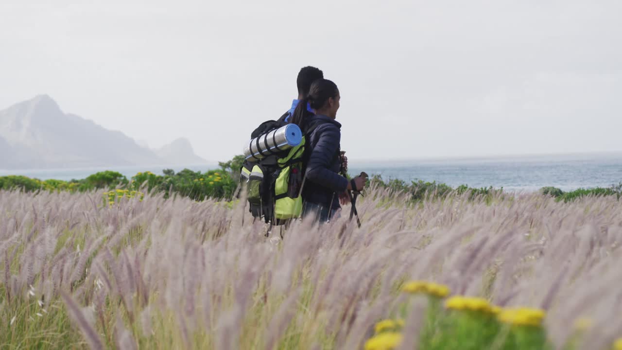 아프리카계 미국인 부부가 산에서 트레킹을 하는 동안  ⁇ 고 있습니다.