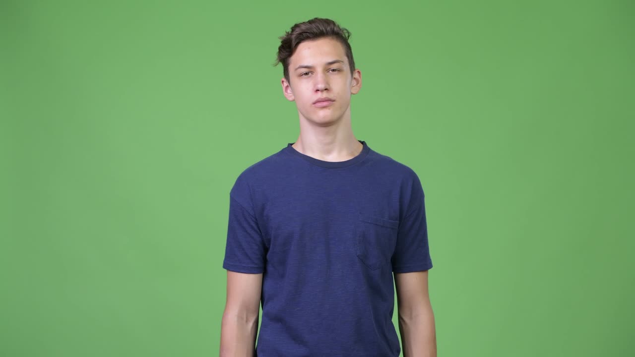 Young handsome teenage boy shrugging