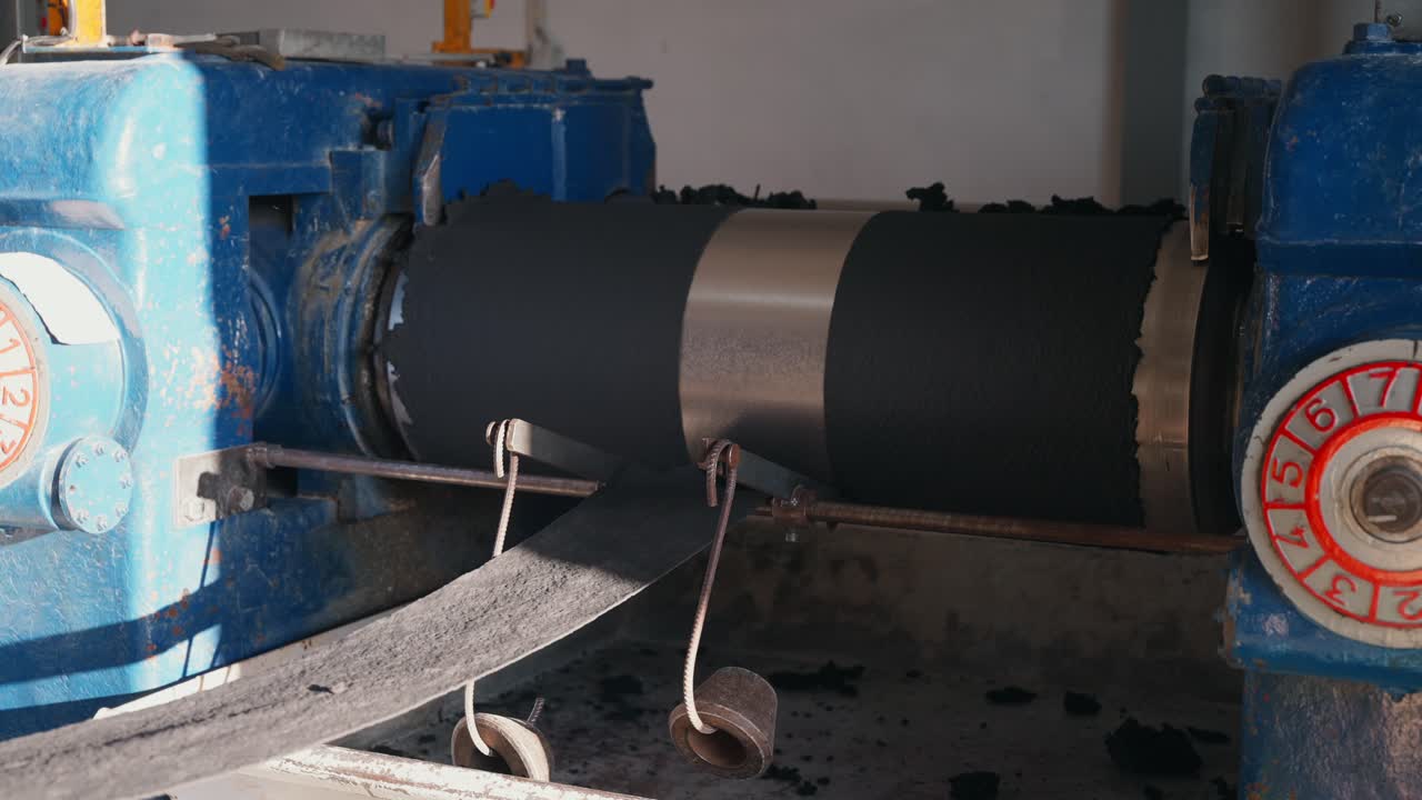 Industrial roller machine forming rubber sheet inside recycling factory