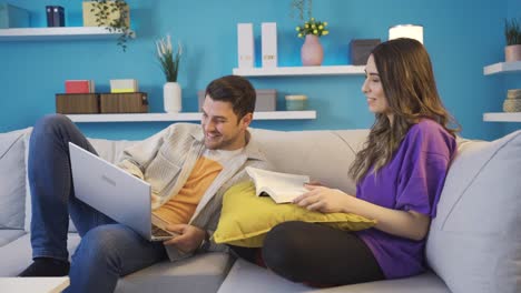 Happy-young-couple-smiling-at-each-other-in-their-loving-home-spending-time-together,-consulting-each-other.