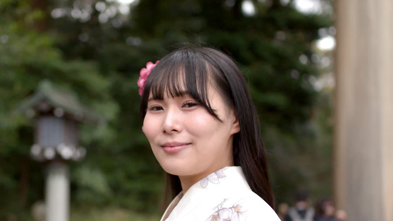 Ritratto in primo piano di una donna sorridente che indossa un kimono in un santuario shintoista a Tokyo.