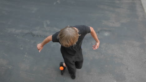 un hombre hace malabares con una pelota de un lado a otro sobre su cabeza con los pies