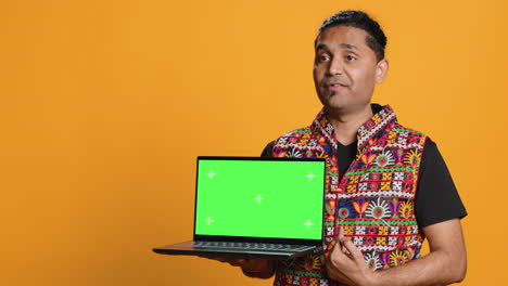 Tech-content-creator-doing-influencer-marketing-using-green-screen-laptop