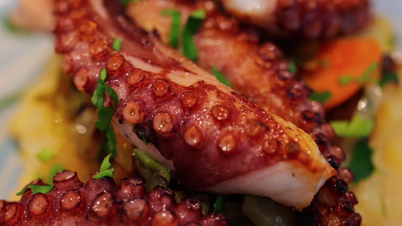 Close up of grilled octopus on a puree and a piece of lemon at a restaurant