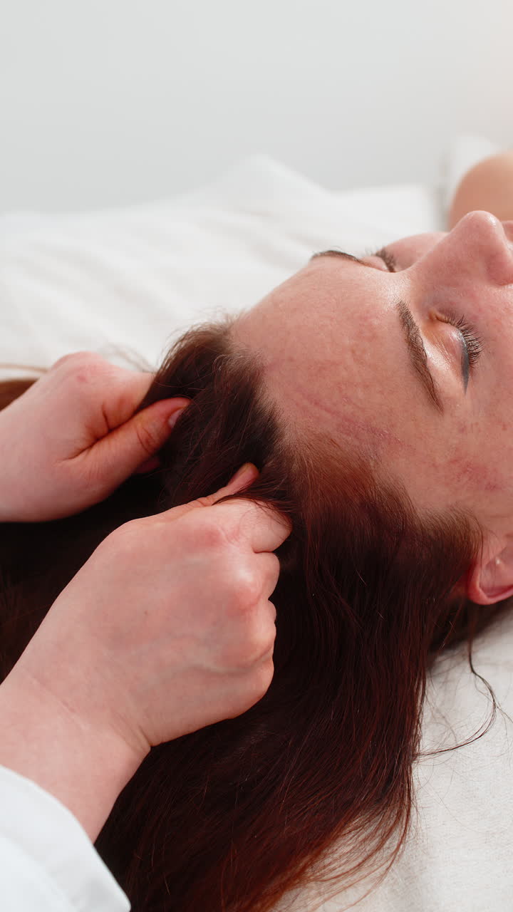 Woman experiences scalp massage in cosmetology beautician performs soothing therapeutic procedure