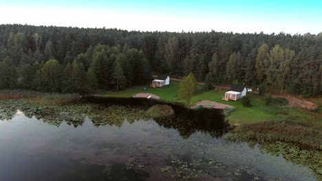 cabin houses by the lush forest near the calm lake in rogowko, poland