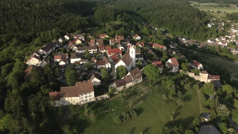 drone footage flying forward towards the historic church tower in aach, baden-württemberg, showcasing the old town and surrounding village with a scenic backdrop.
