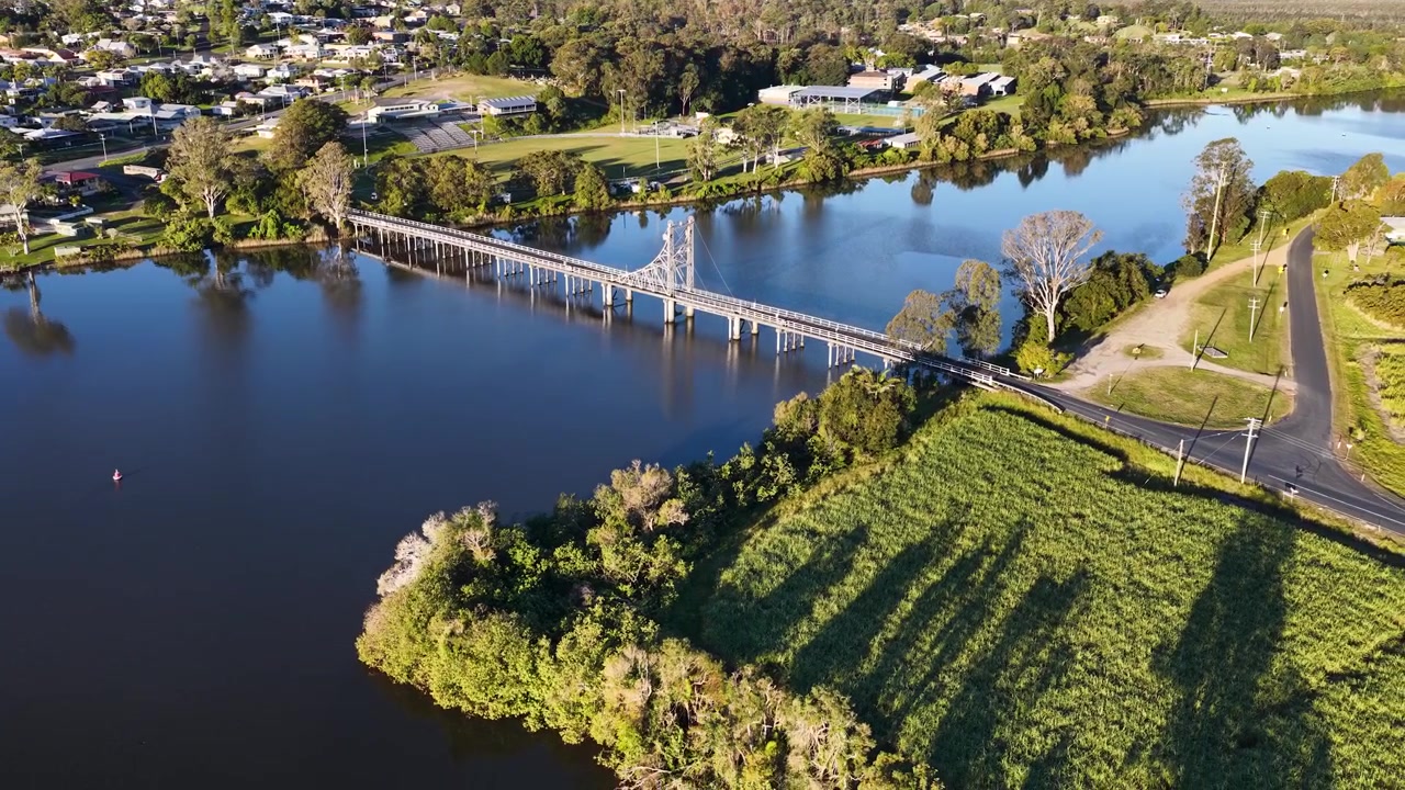 Toma aérea con dron de un puente sobre aguas tranquilas de un río en Maclean, Nueva Gales del Sur