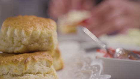 foto de cerca de una persona con el tradicional té de la tarde británico con crema de bollos y mermelada 4