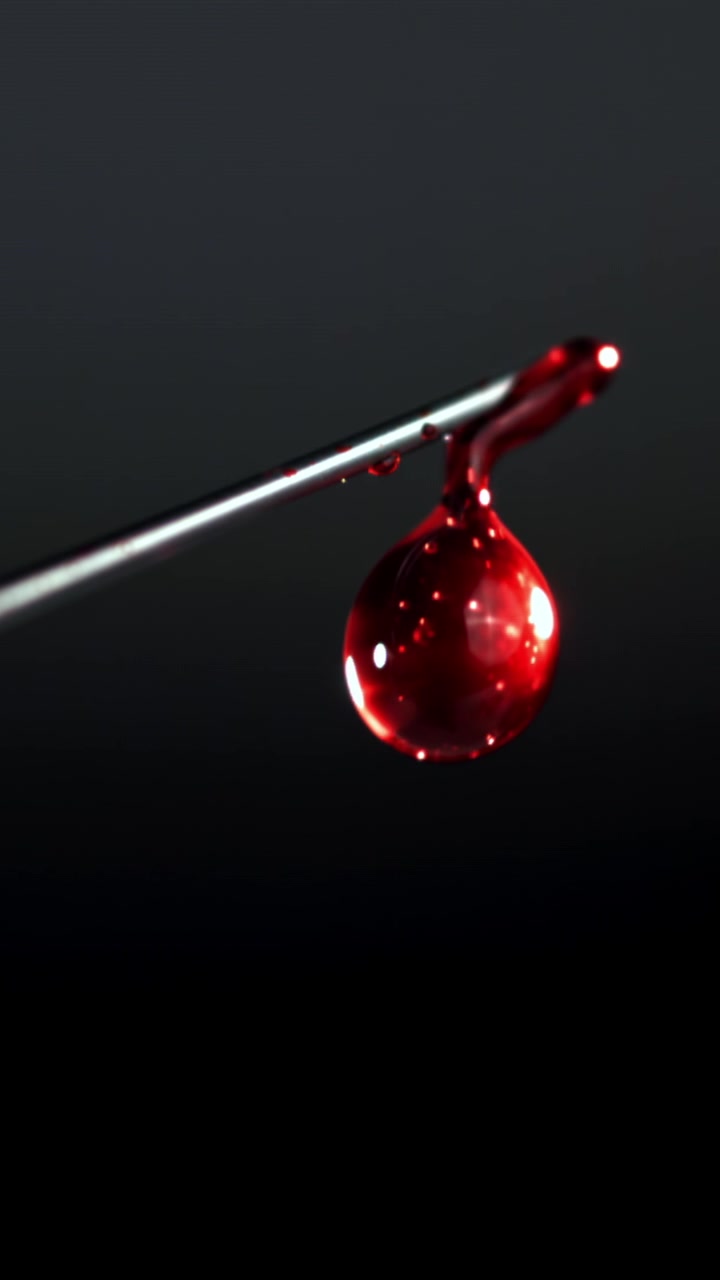 Close-up of a Red Blood Drop Dripping from a Medical Needle