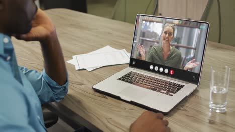 African-american-man-using-laptop-for-video-call,-with-business-colleague-on-screen