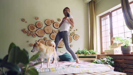 woman and dog dancing on a bed