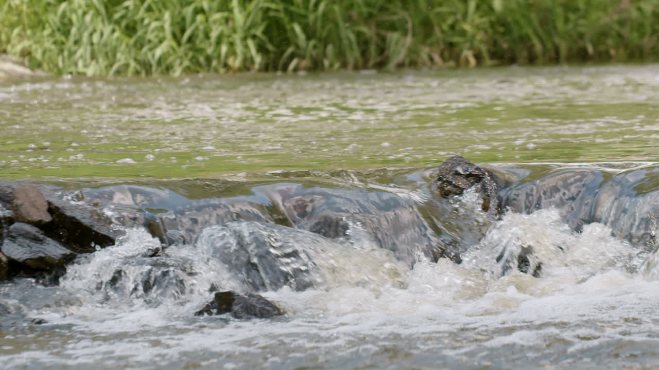 cascadas de corriente de río que fluye sobre rocas, cacerola de cámara lenta