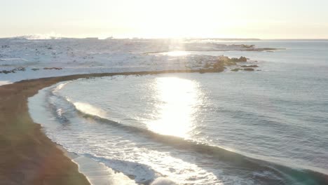 intense sunlight at sandvik beach in iceland during winter time, aerial