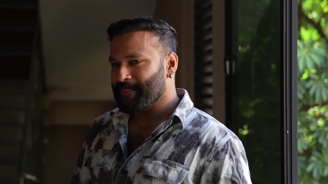 Happy man posing for camera with genuine friendly smile showing thumbs up and victory