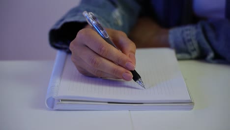 Close-up-of-a-female-student-sketching-shapes-in-the-notebook