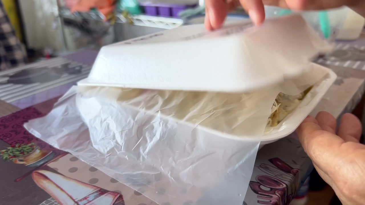 Chicken chilaquiles served in a takeaway container, a popular Mexican breakfast