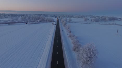 Toma-Aérea-De-Establecimiento-De-Un-Paisaje-Rural-Con-Carreteras-Y-Automóviles,-Campo,-Campos-Agrícolas-Y-árboles-Cubiertos-De-Nieve,-Clima-Frío,-Luz-De-La-Hora-Dorada,-Amplia-Toma-De-Drones-Avanzando