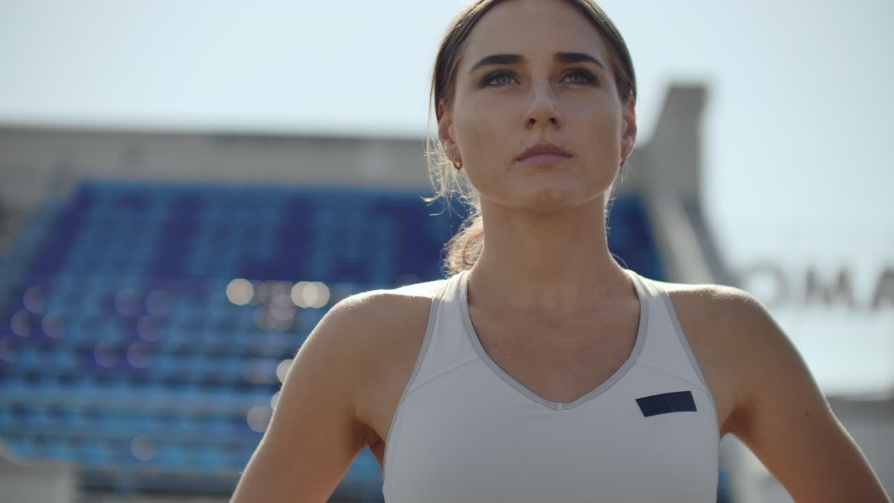 A time lapse portrait of beautiful woman running on the stadium bleachers with concentrated deep breathing and motivating myself and consciousness for the race. Discard unnecessary emotions and tune in to win preparing for the race