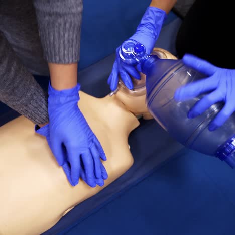 training on a medical mannequin doll. learning to do chest compression on a dummy. first aid cardiopulmonary resuscitation training. top view.