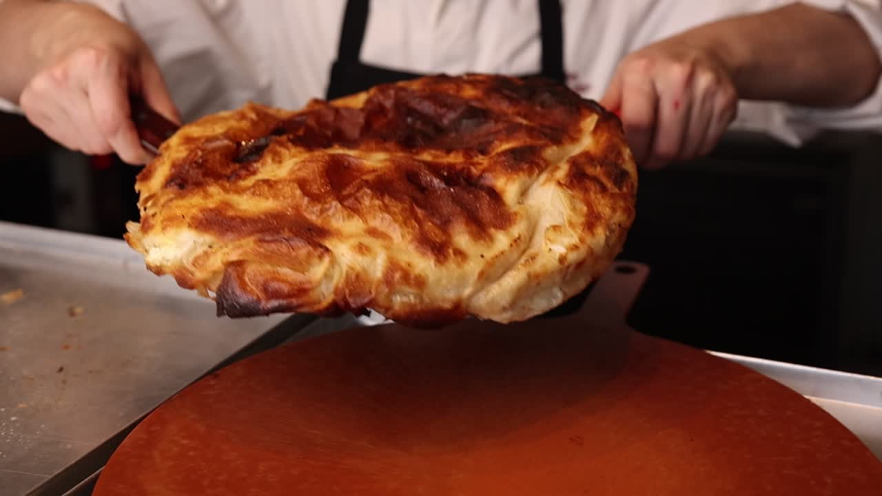 Chef che tiene un pasticcino salato dorato appena sfornato