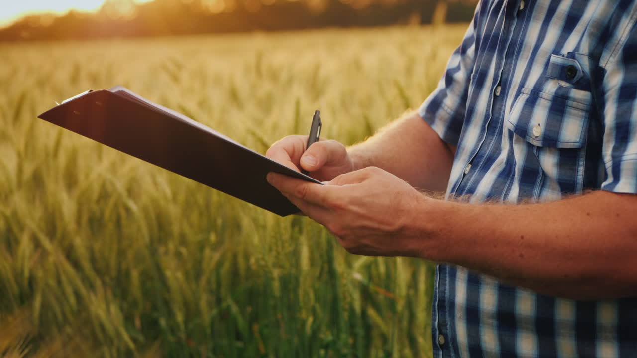 фермер подписывает документ и пожимает руку партнеру на фоне пшеничного поля