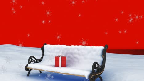 Animation-of-snow-falling-over-red-christmas-present-on-snow-covered-bench