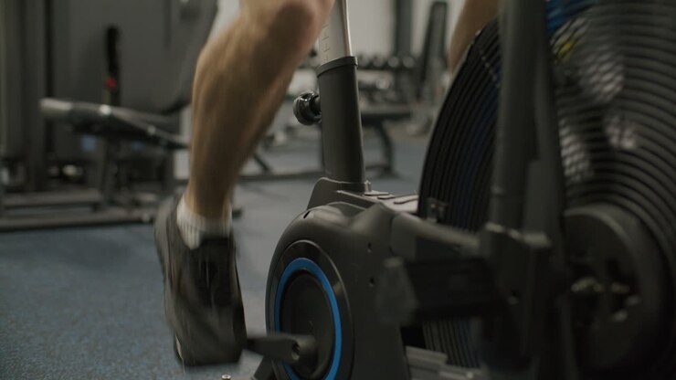Athletic Man Doing Cardio Workout on Air Bike in Gym